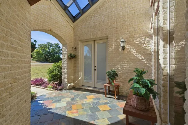 a view of a porch with chairs and potted plants