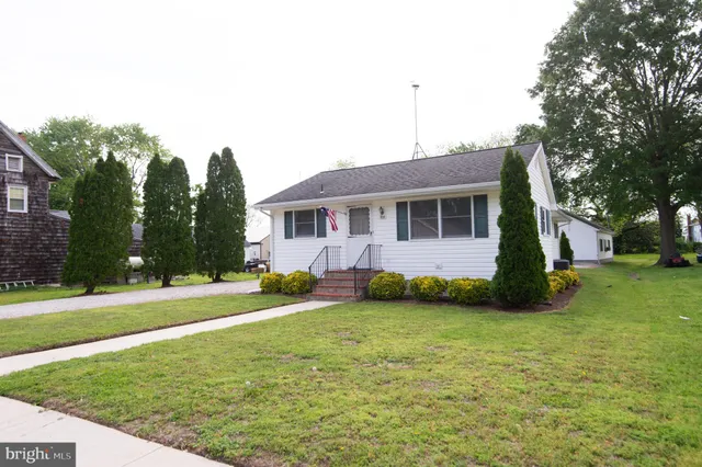 a view of a house with a yard and trees