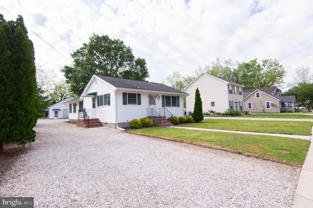 a view of house with outdoor space and trees in the background