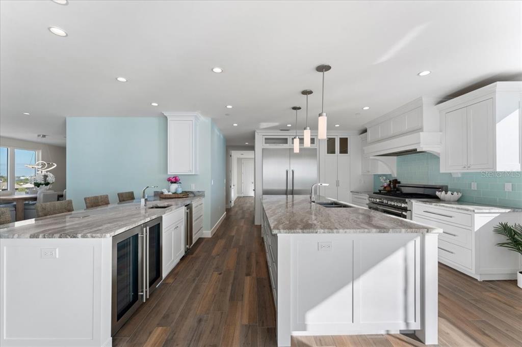 2708 North Beach Road, Unit 5 Englewood, FL 34223 - Photo 26 of 82 a large kitchen with stainless steel appliances kitchen island granite countertop a large stove a sink a refrigerator and island with wooden floor