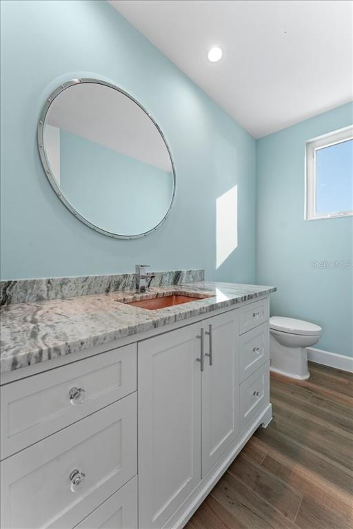 2708 North Beach Road, Unit 5 Englewood, FL 34223 - Photo 42 of 82 a bathroom with a granite countertop toilet a sink and mirror