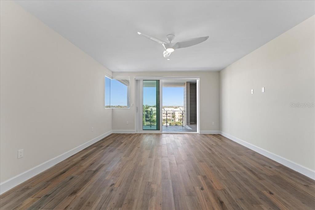 2708 North Beach Road, Unit 5 Englewood, FL 34223 - Photo 46 of 82 an empty room with wooden floor and windows