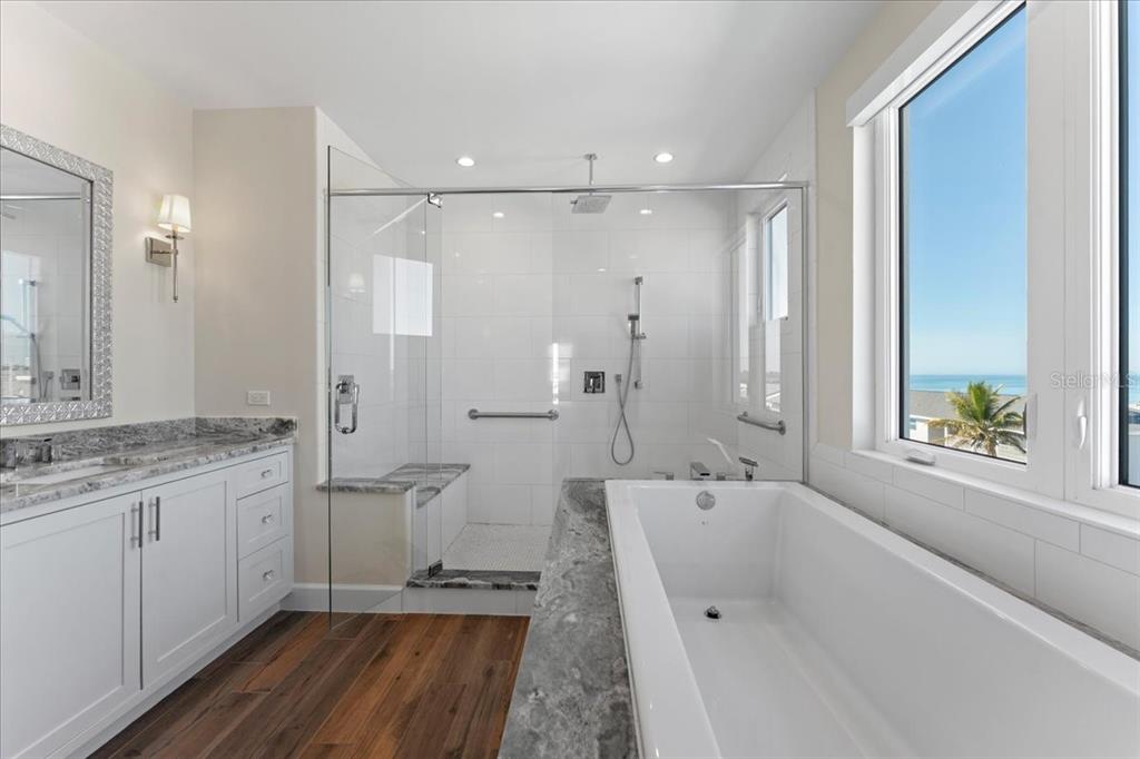 2708 North Beach Road, Unit 5 Englewood, FL 34223 - Photo 50 of 82 a spacious bathroom with a granite countertop sink a toilet a large mirror a bathtub and shower