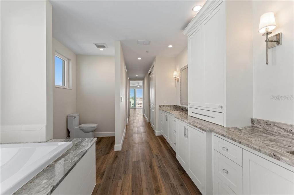 2708 North Beach Road, Unit 5 Englewood, FL 34223 - Photo 51 of 82 a bathroom with a granite countertop sink a toilet a large mirror and vanity