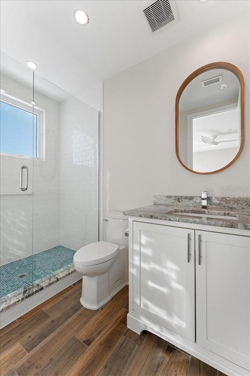 2708 North Beach Road, Unit 5 Englewood, FL 34223 - Photo 65 of 82 a bathroom with a granite countertop toilet sink and mirror