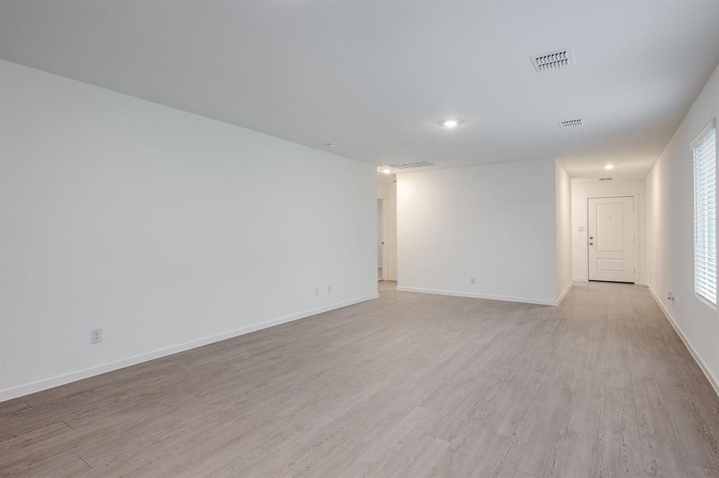 1119 Barbary Flds Street Forney, TX 75126 - Photo 3 of 14 an empty room with wooden floor and windows