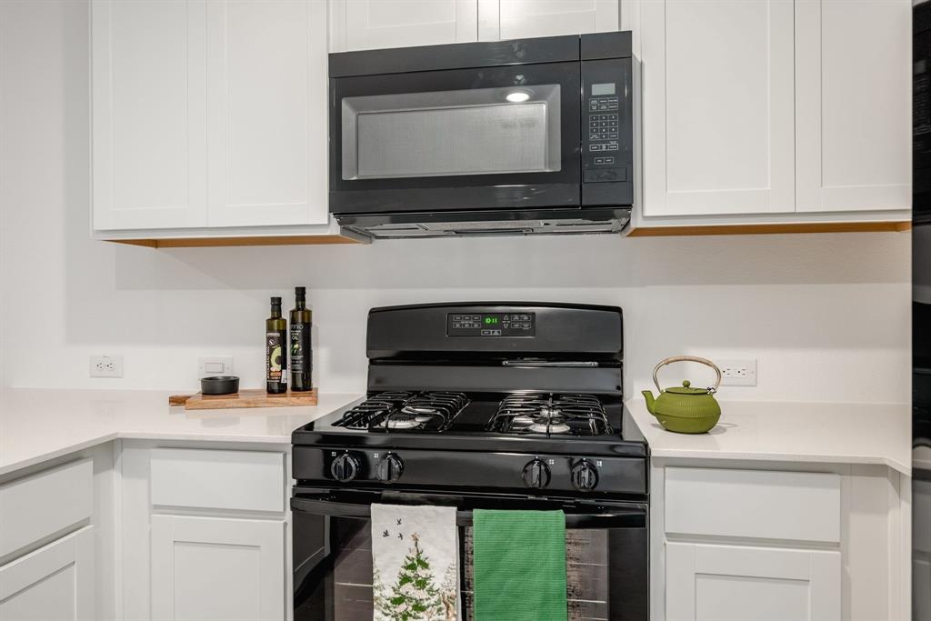 1119 Barbary Flds Street Forney, TX 75126 - Photo 6 of 14 a kitchen with a stove and a microwave
