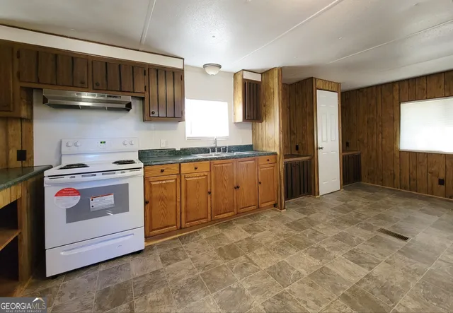 a kitchen with stainless steel appliances granite countertop a stove a sink and a refrigerator