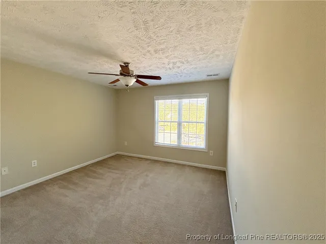 an empty room with closet and windows