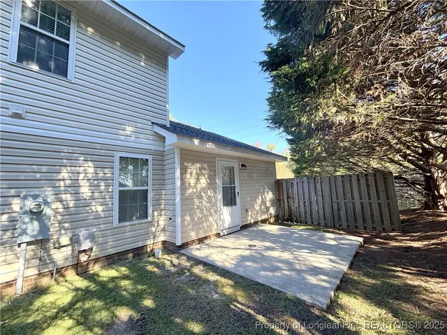 a view of a house with a small yard and wooden fence