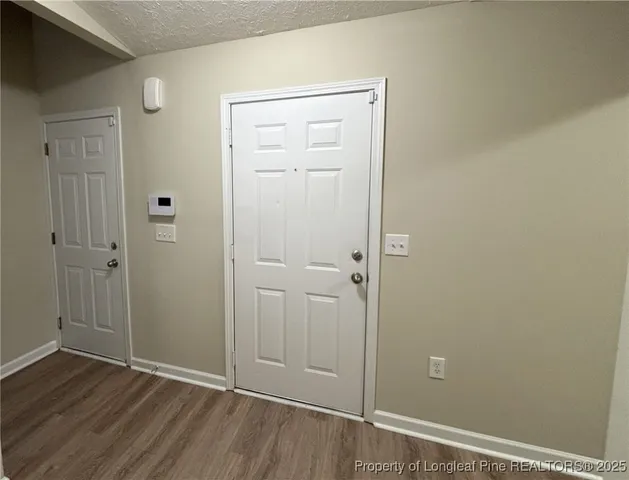 a view of empty room with wooden floor and ceiling fan