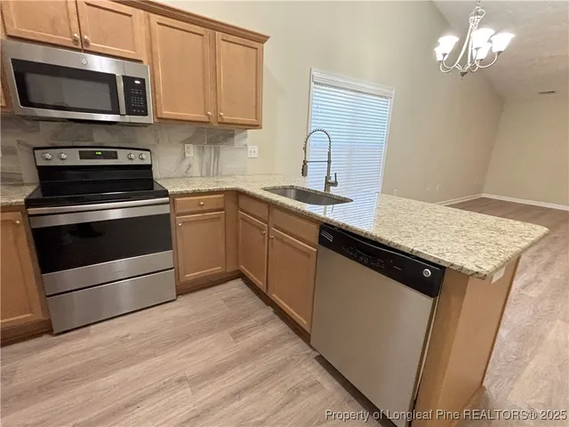 a kitchen with stainless steel appliances granite countertop a refrigerator stove microwave and sink