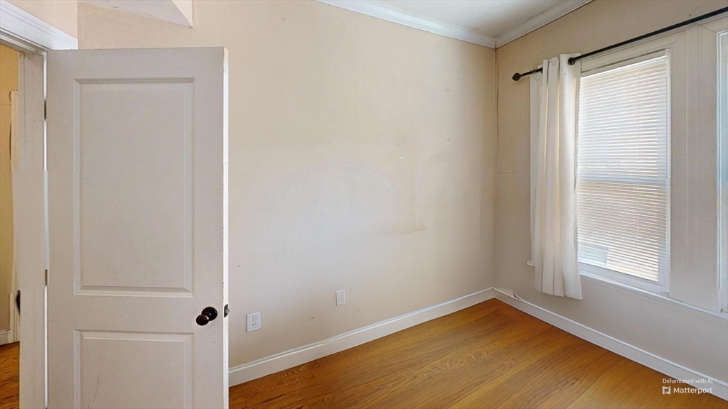 2975 Washington Street, Unit 2 Boston, MA 02119 - Photo 4 of 8 a view of a room with wooden floor and a window