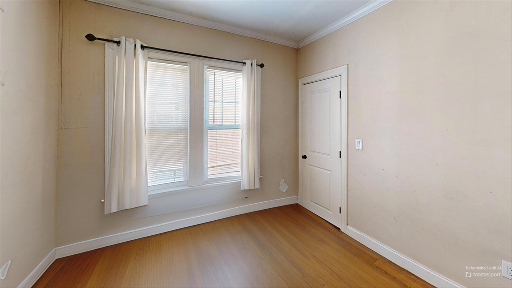 2975 Washington Street, Unit 2 Boston, MA 02119 - Photo 6 of 8 an empty room with wooden floor and windows