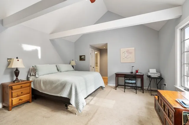 a spacious bedroom with a bed and a table in it