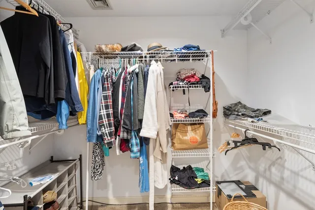 a view of walk in closet with clothes and shoes