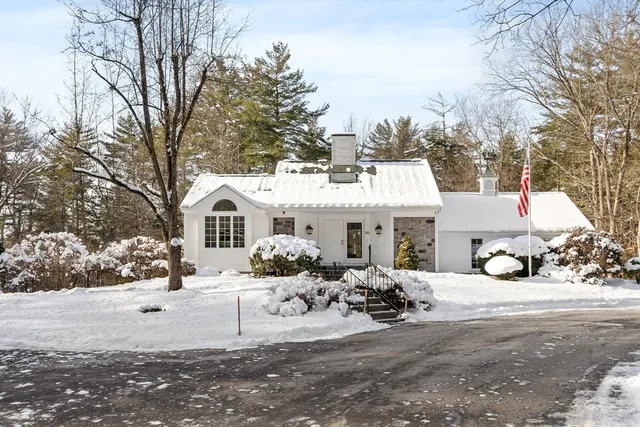 a view of a white house covered with snow in front of it