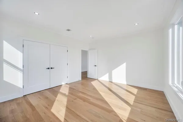 a view of a room has wooden floor and window