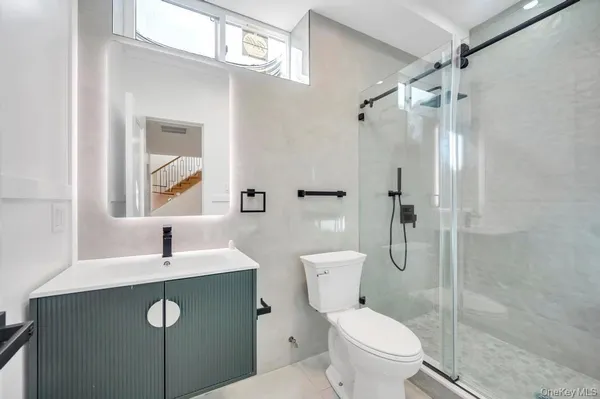 a bathroom with a sink a toilet and shower