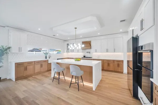 a kitchen with a refrigerator a sink dishwasher and a stove with wooden floor