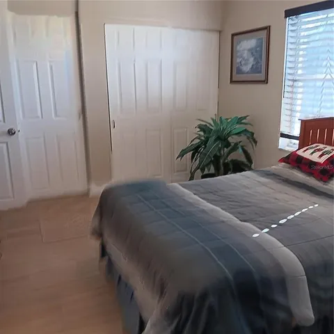 a bedroom with a bed and a potted plant