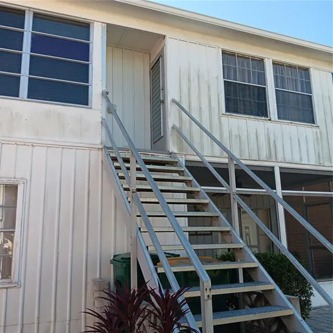 a view of staircase with wooden floor and white walls