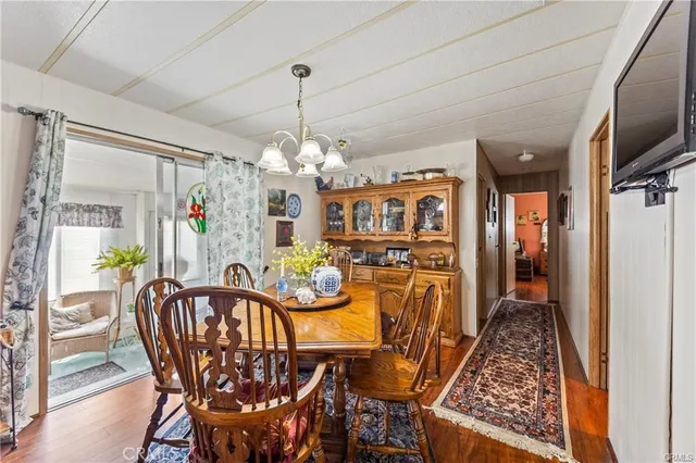 a view of a dining room with furniture a chandelier and wooden floor