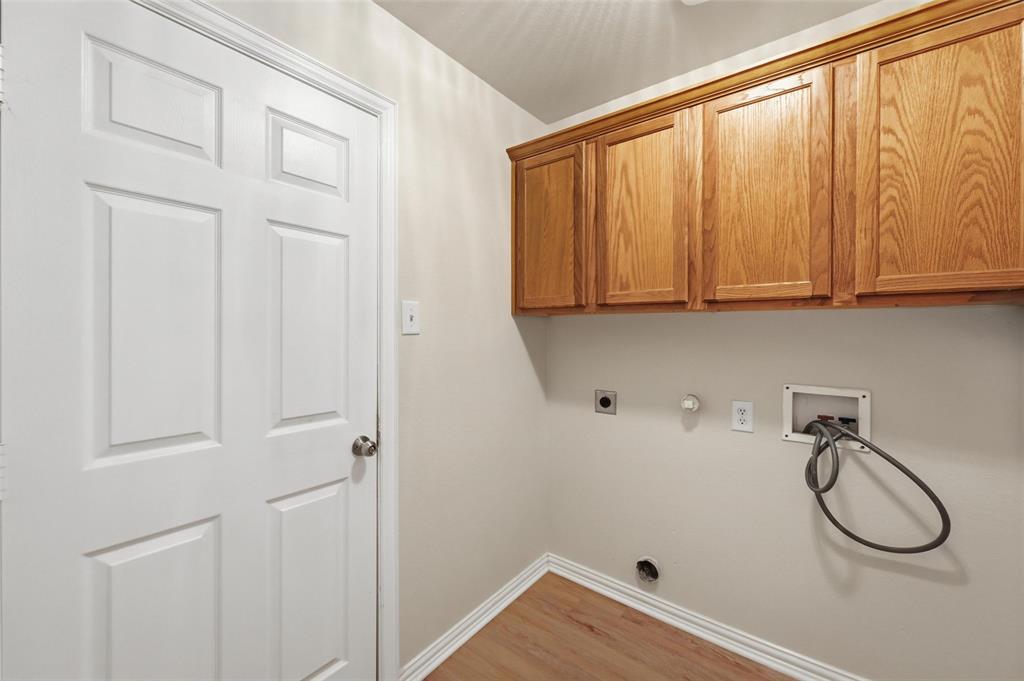 4416 Ridgeway Drive Mansfield, TX 76063 - Photo 25 of 27 Laundry area featuring built in cabinets and laundry hookups.