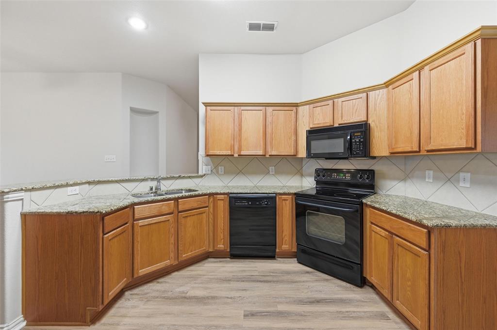 4416 Ridgeway Drive Mansfield, TX 76063 - Photo 8 of 27 Kitchen with black appliances, granite countertops