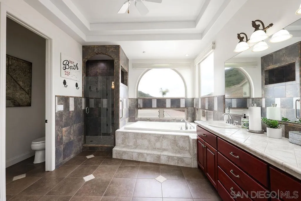 23085 Tombill Road Ramona, CA 92065 - Photo 13 of 43 a bathroom with a tub sink and mirror
