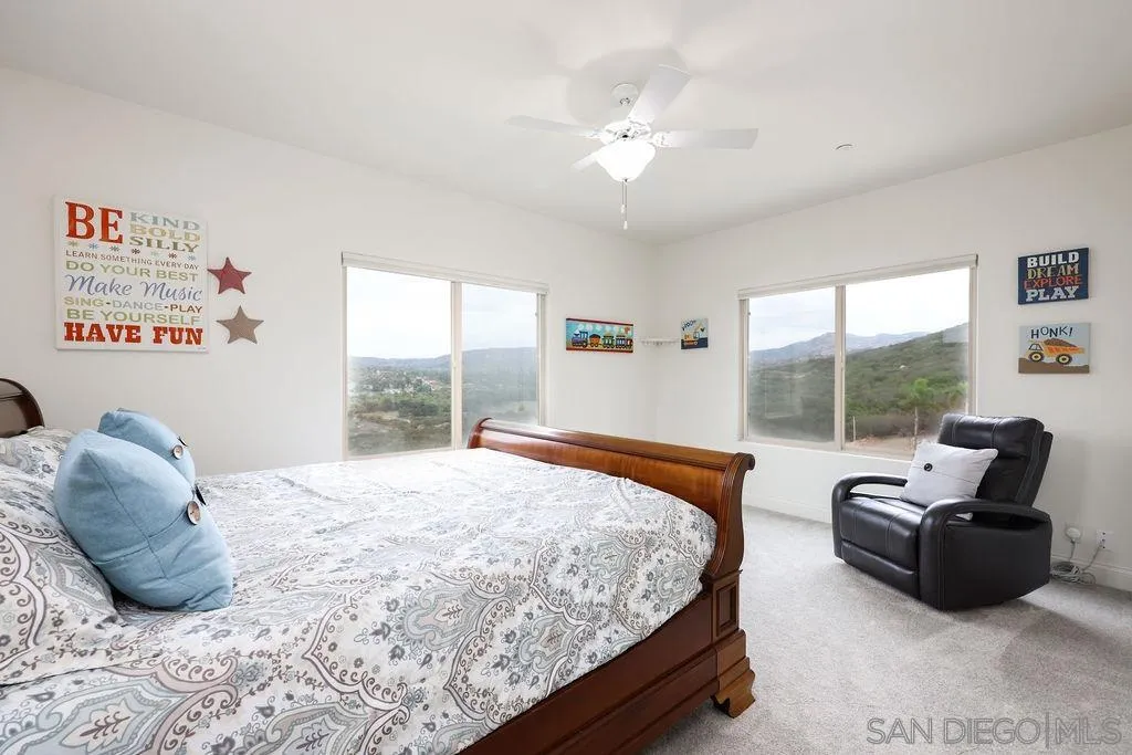 23085 Tombill Road Ramona, CA 92065 - Photo 19 of 43 a bedroom with a bed a couch and a window