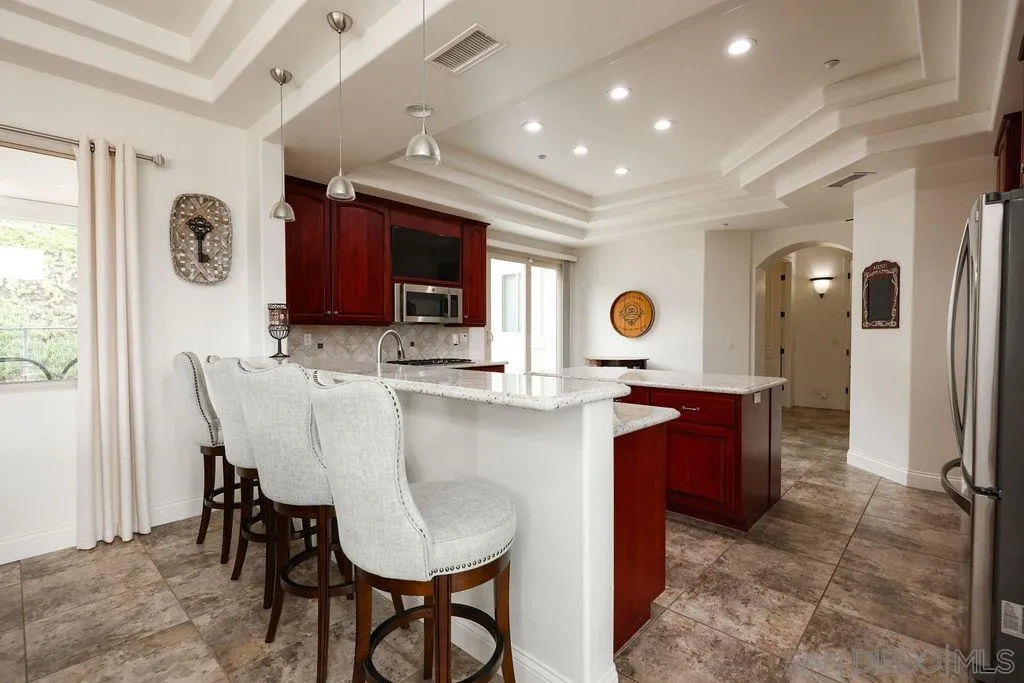 23085 Tombill Road Ramona, CA 92065 - Photo 8 of 43 a kitchen with stainless steel appliances kitchen island granite countertop a table chairs sink and window