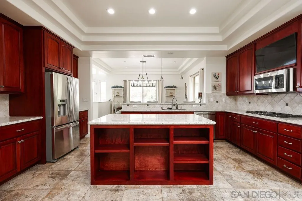 23085 Tombill Road Ramona, CA 92065 - Photo 10 of 43 a kitchen with stainless steel appliances granite countertop a stove refrigerator and microwave
