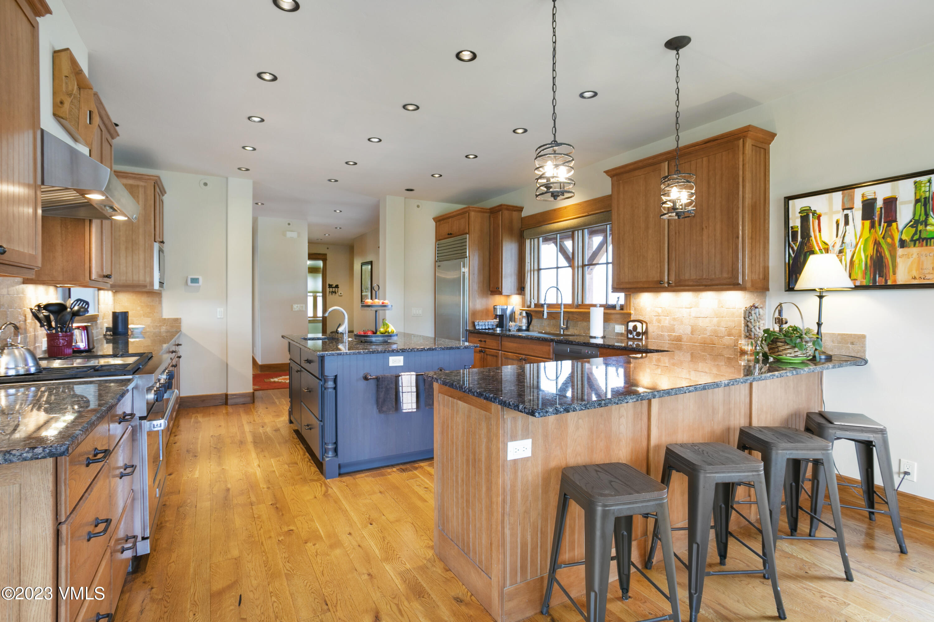106 East Double Hitch Eagle, CO 81631 - Photo 5 of 28 a kitchen with stainless steel appliances kitchen island granite countertop a table chairs in it and a wooden floors