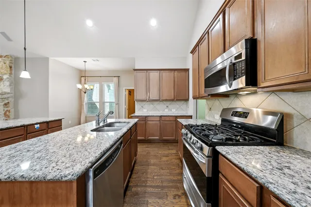 a view of an empty room with a chandelier fan
