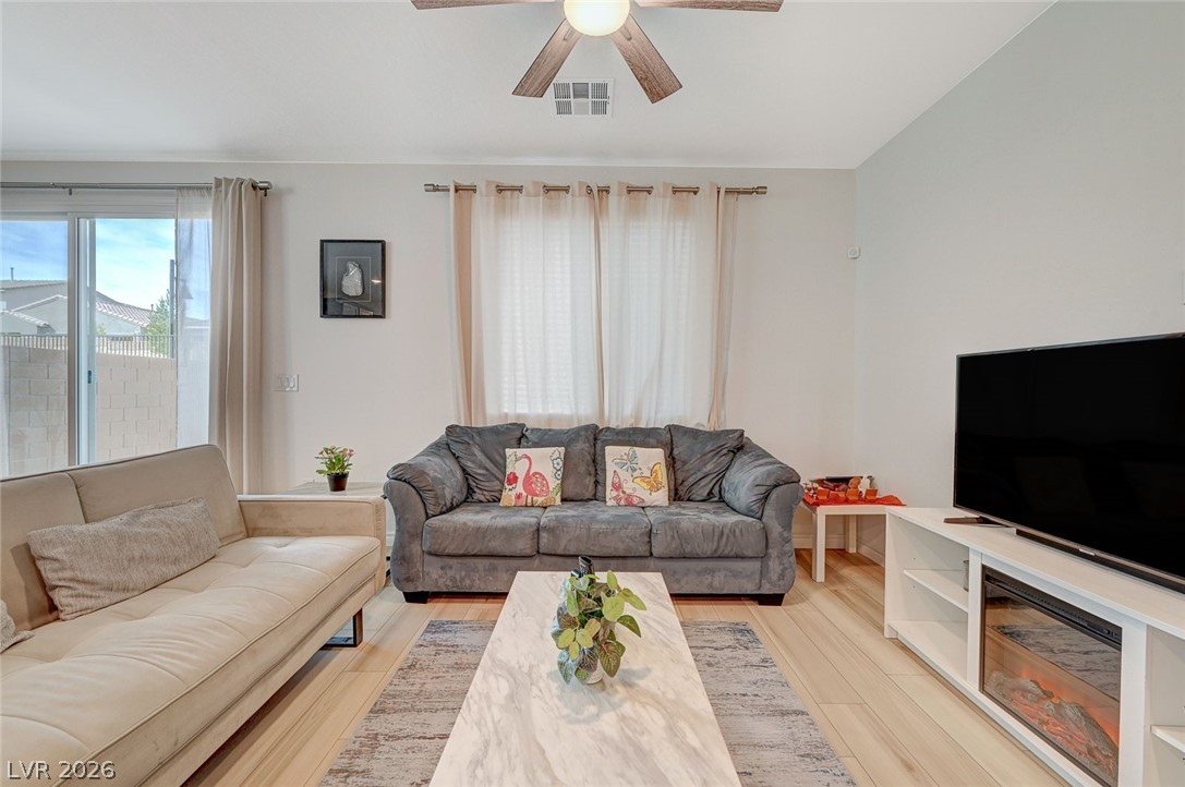 8855 Roadrunner Ravine Street Las Vegas, NV 89166 - Photo 12 of 54 Living room with light wood-style flooring, visible vents, and ceiling fan