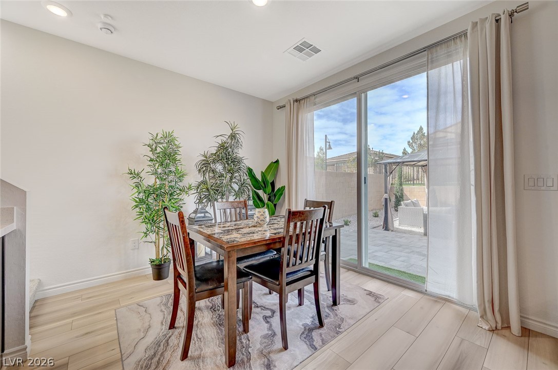8855 Roadrunner Ravine Street Las Vegas, NV 89166 - Photo 20 of 54 Dining room featuring light wood finished floors, baseboards, and visible vents