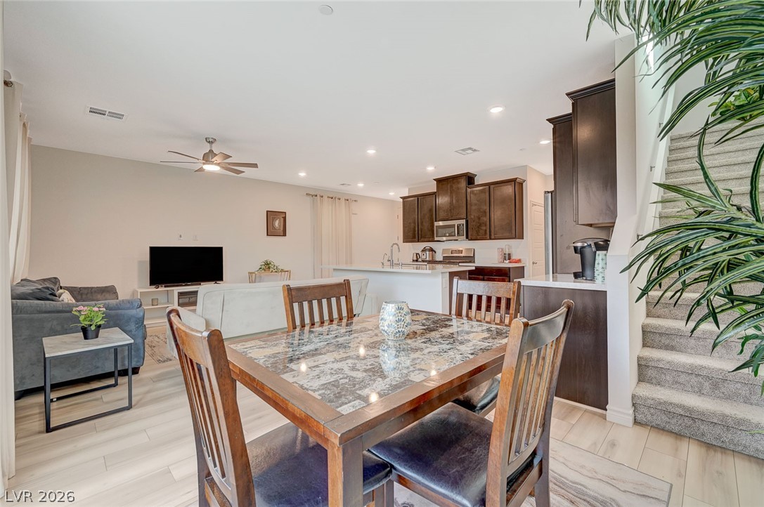 8855 Roadrunner Ravine Street Las Vegas, NV 89166 - Photo 21 of 54 Dining room with ceiling fan, light wood-style flooring, recessed lighting, visible vents, and stairs