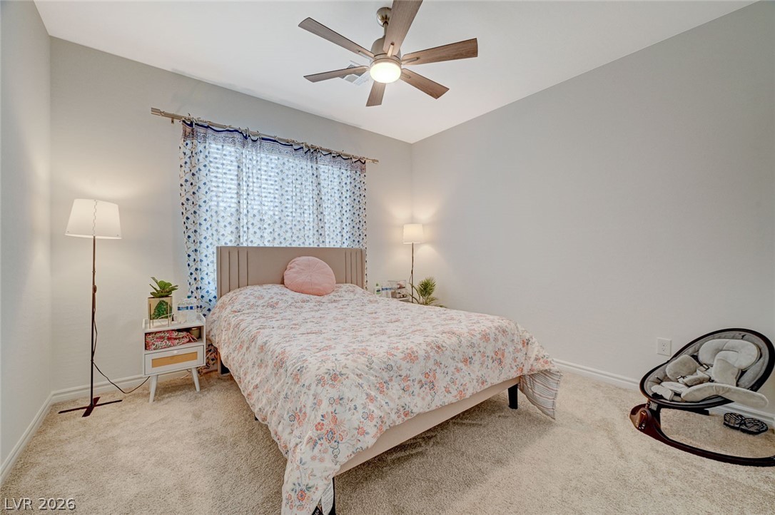 8855 Roadrunner Ravine Street Las Vegas, NV 89166 - Photo 25 of 54 Bedroom with a ceiling fan, light colored carpet, and baseboards