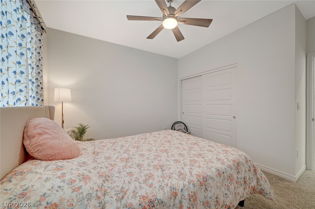 8855 Roadrunner Ravine Street Las Vegas, NV 89166 - Photo 26 of 54 Carpeted bedroom featuring a closet, ceiling fan, and baseboards
