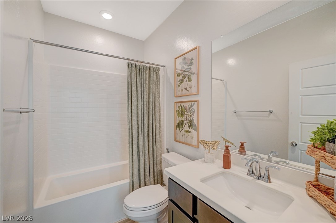 8855 Roadrunner Ravine Street Las Vegas, NV 89166 - Photo 33 of 54 Bathroom with vanity, toilet, and shower / bathtub combination with curtain