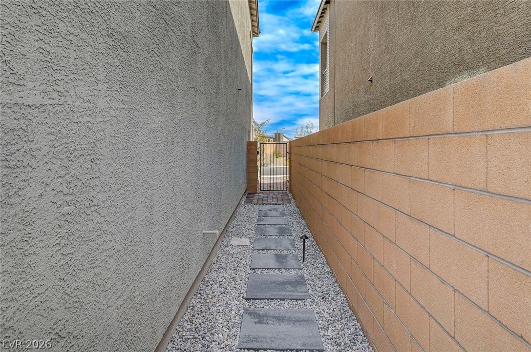 8855 Roadrunner Ravine Street Las Vegas, NV 89166 - Photo 47 of 54 View of side of property featuring fence, a gate, and stucco siding