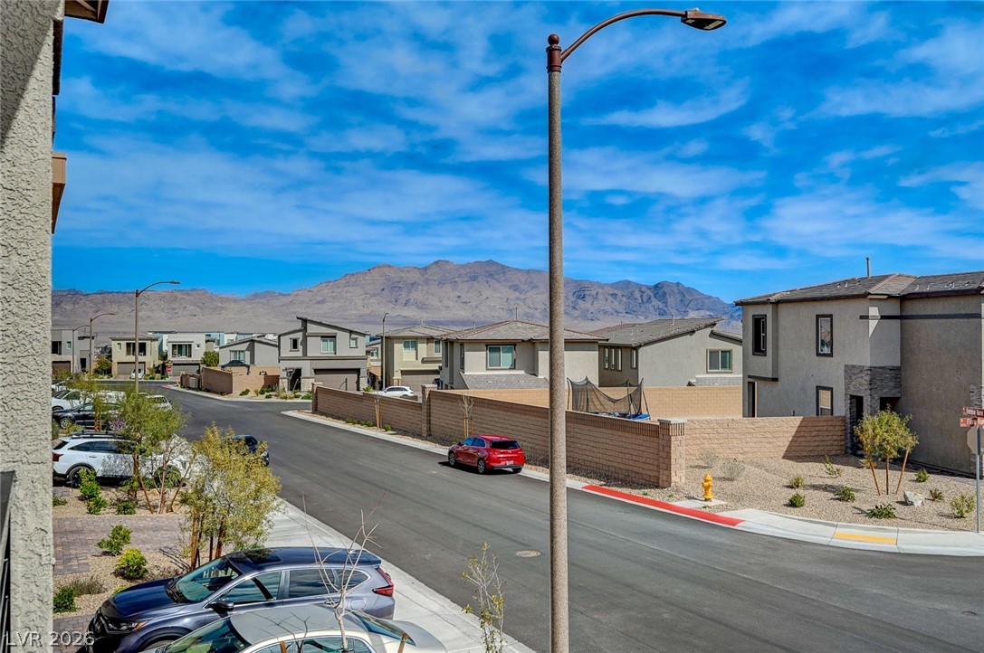 8855 Roadrunner Ravine Street Las Vegas, NV 89166 - Photo 48 of 54 View of road with street lighting, a residential view, a mountain view, and curbs