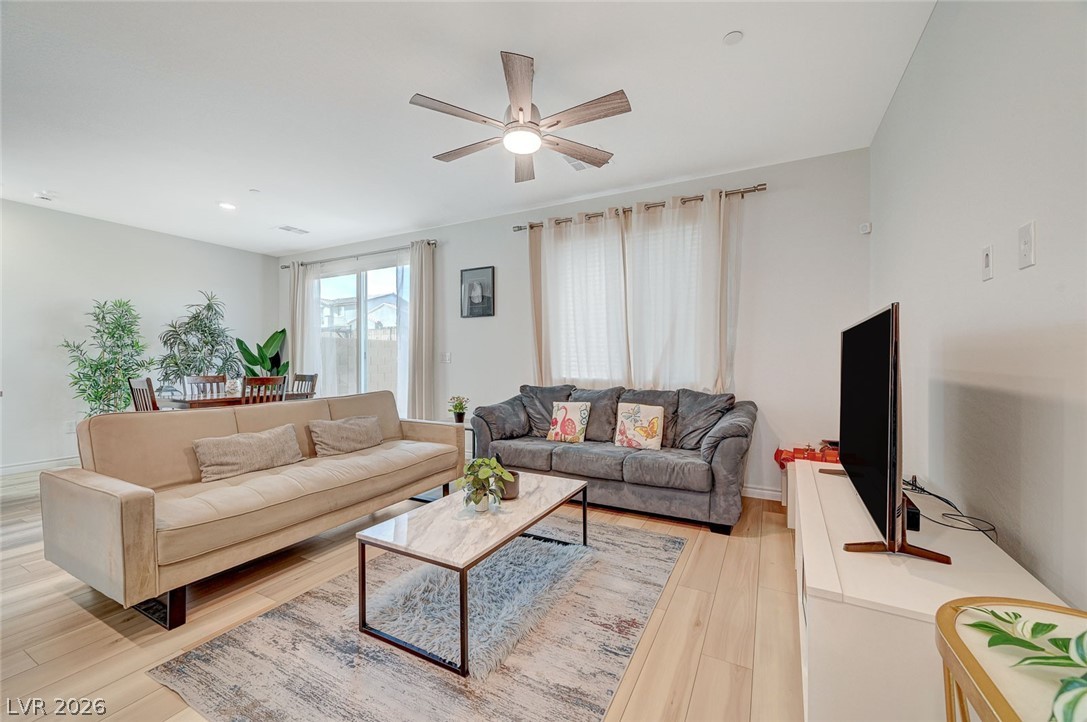 8855 Roadrunner Ravine Street Las Vegas, NV 89166 - Photo 7 of 54 Living room featuring ceiling fan, light wood-style flooring, and baseboards
