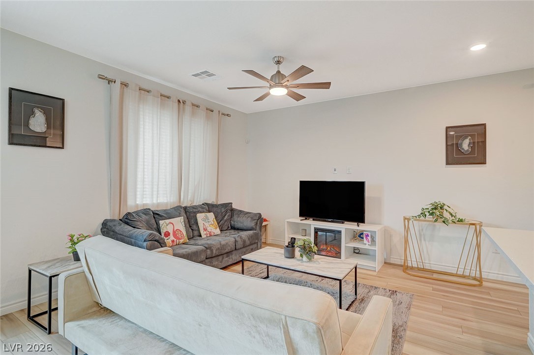 8855 Roadrunner Ravine Street Las Vegas, NV 89166 - Photo 9 of 54 Living room featuring recessed lighting, visible vents, light wood-style flooring, ceiling fan, and baseboards