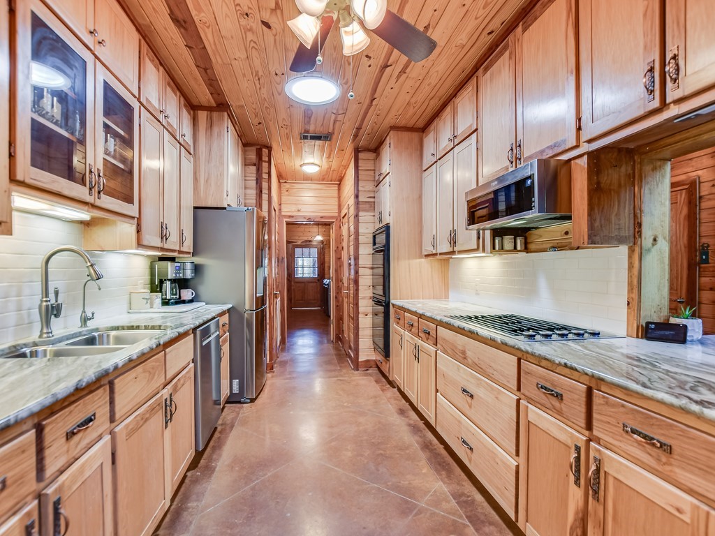 254 Middleton Road Spicewood, TX 78669 - Photo 7 of 32 a kitchen with stainless steel appliances granite countertop a sink and cabinets