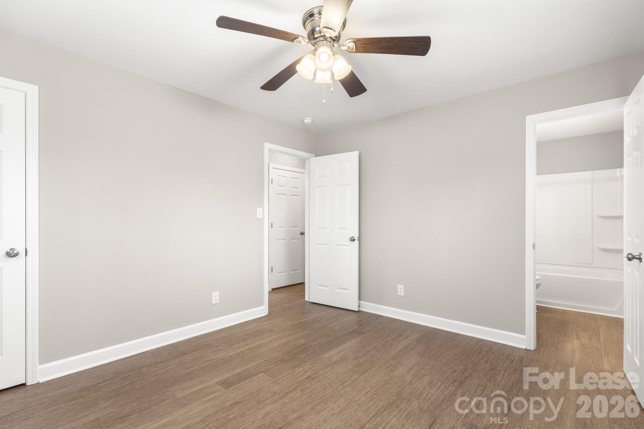 11805 Harrisburg Road Indian Land, SC 29707 - Photo 23 of 47 an empty room with wooden floor ceiling fan and windows
