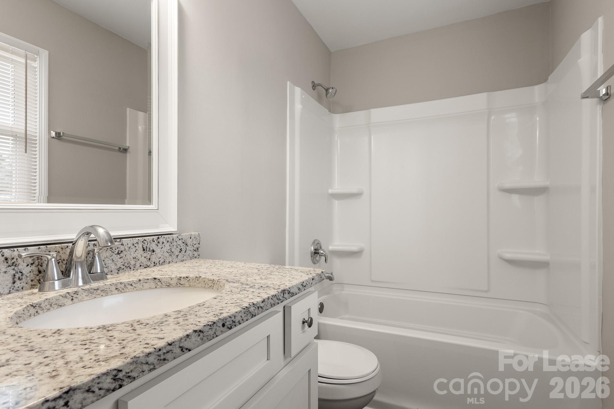 11805 Harrisburg Road Indian Land, SC 29707 - Photo 24 of 47 a bathroom with a granite countertop sink a toilet and bathtub