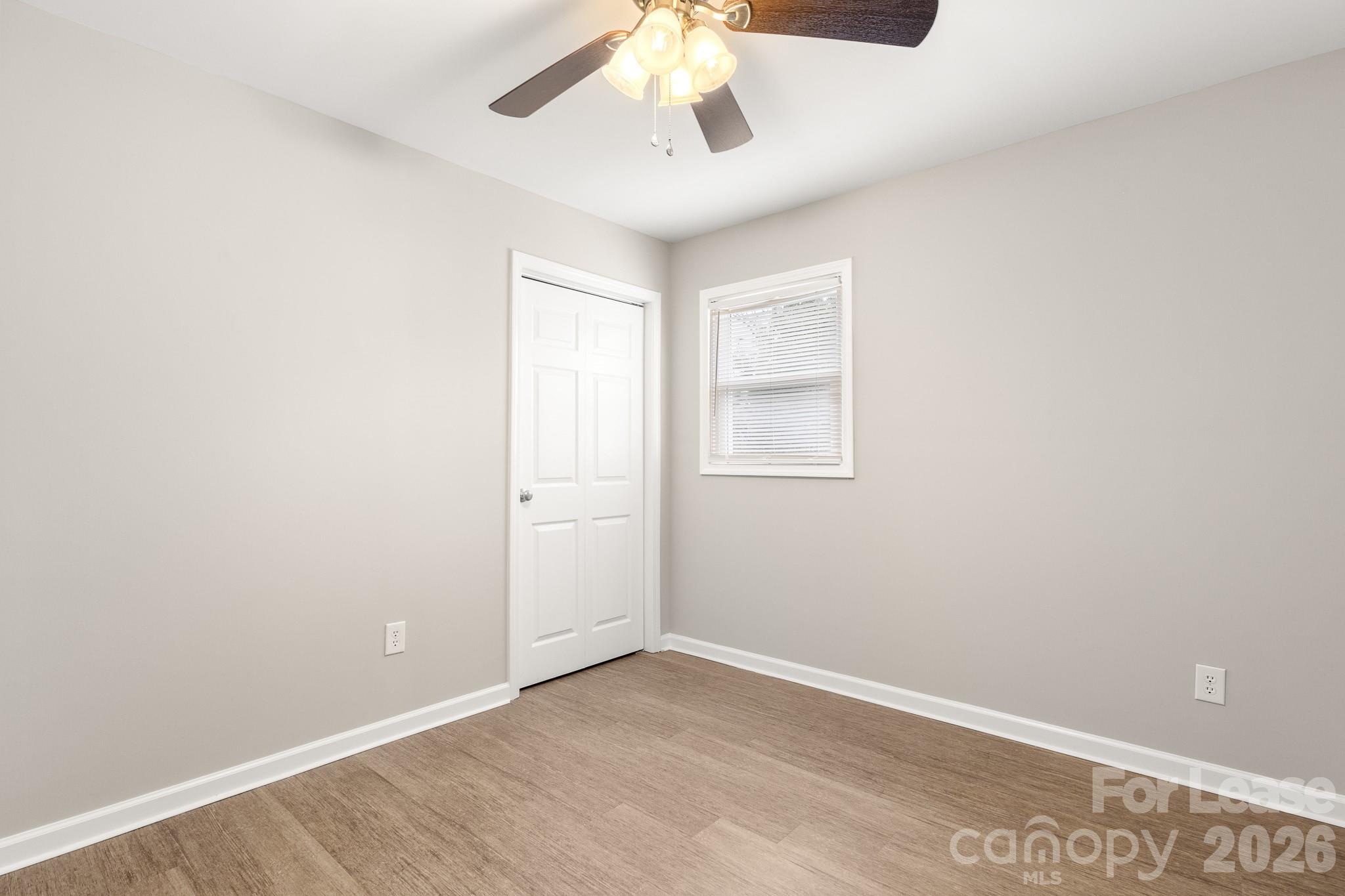 11805 Harrisburg Road Indian Land, SC 29707 - Photo 36 of 47 an empty room with a chandelier fan and windows