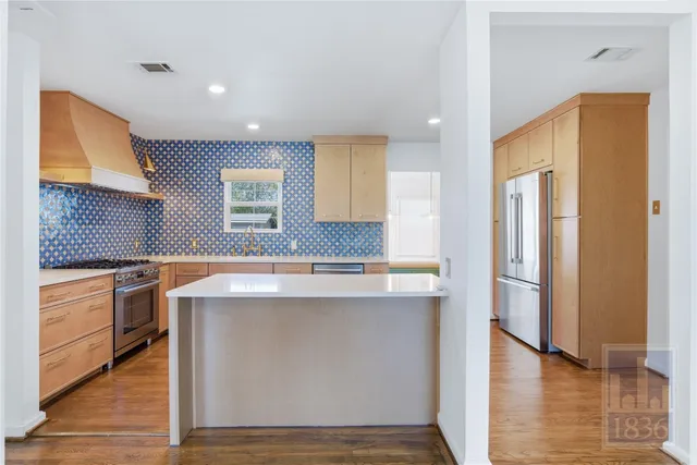 a kitchen with stainless steel appliances granite countertop a refrigerator a sink and a stove